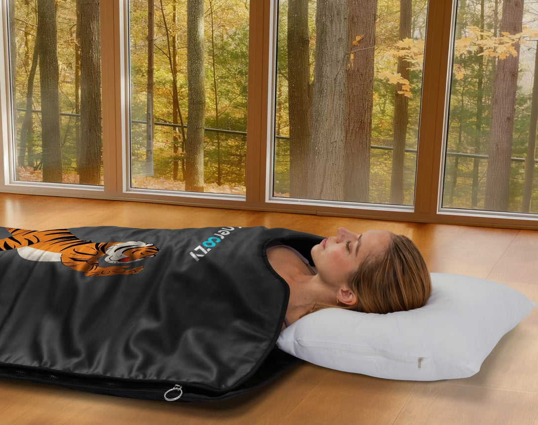 Enercozy 'Wild Orange Wander' Infrared Sauna Blanket folded on a surface, showcasing its vibrant design and luxurious feel for ultimate relaxation and strength.